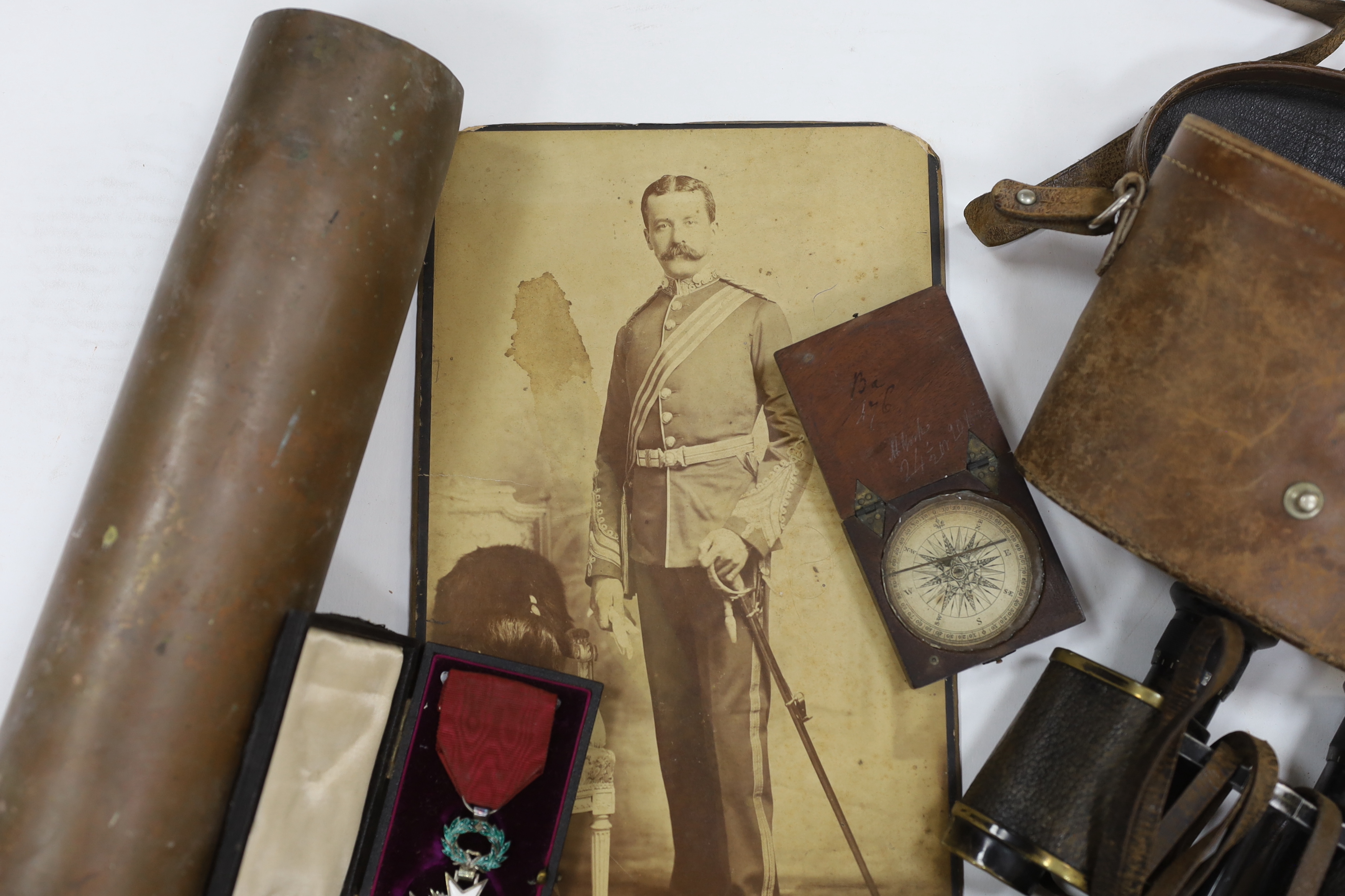 A late 19th century military sash with a related photograph showing the full uniform, a pair of Carl Zeiss binoculars, two compasses, a Belgium Order of the Crown cased medal, and a shell casing